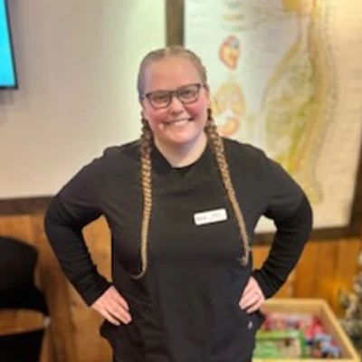 Elissa smiling in black scrubs.